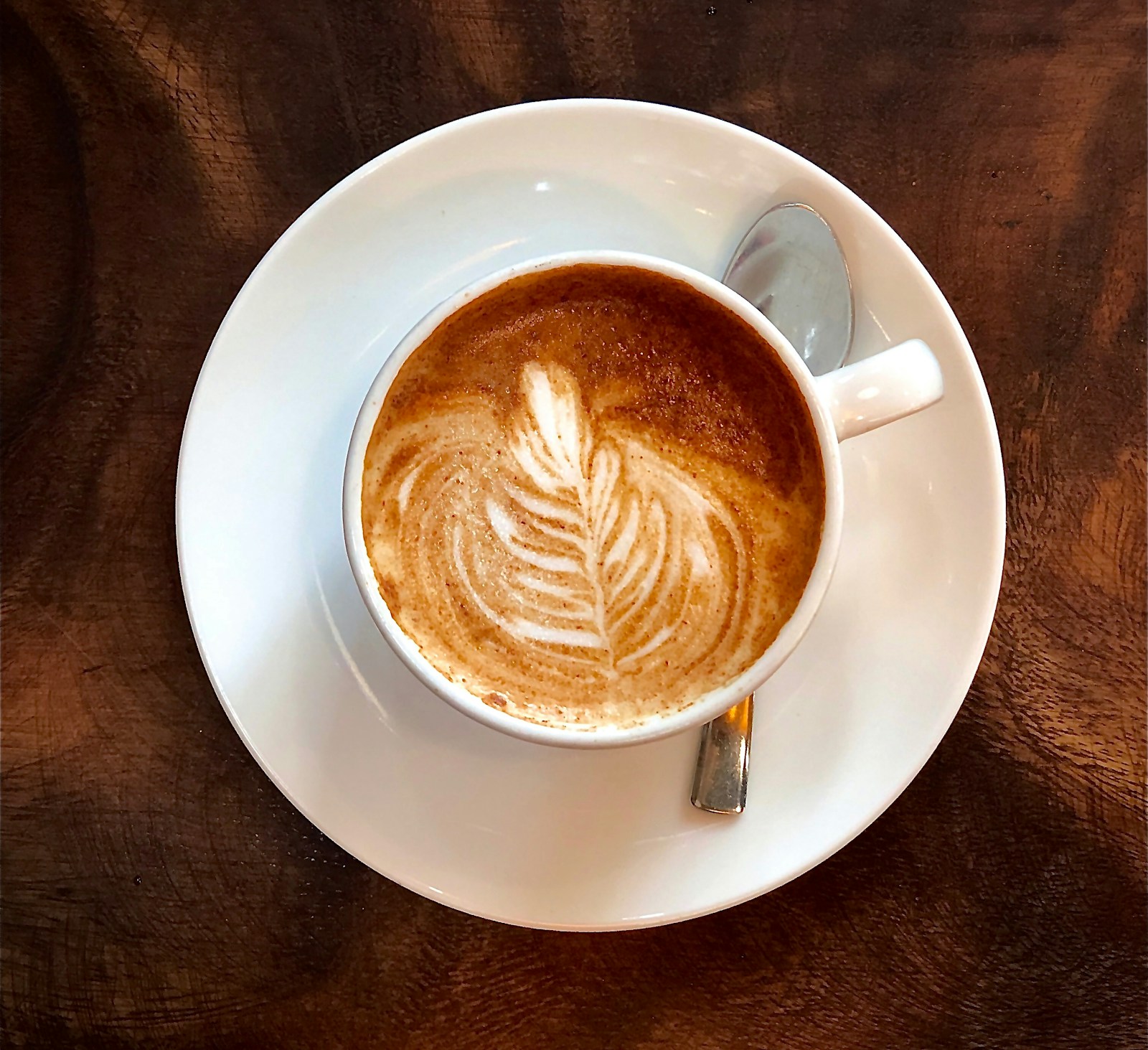 Latte art em cappuccino — bebida premium servida em cafeteria gourmet